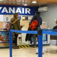 Klienci stoją w kolejce do odprawy Ryanair. Zastanawiasz się, ile kosztuje odprawa na lotnisku?