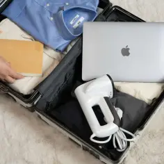 Pakowanie bagażu podręcznego Ryanair: koszula, laptop, książka i parownica do ubrań.