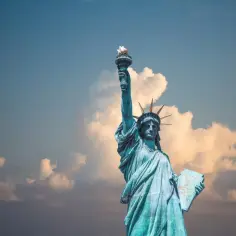 Statua Wolności z pochodnią wzniesioną ku niebu. Planujesz podróż do USA? Pamiętaj o ubezpieczeniu turystycznym!