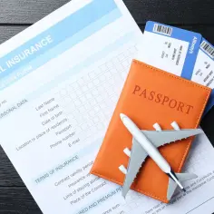 Planujesz podróż? Na zdjęciu paszport, bilety lotnicze i formularz ubezpieczenia podróżnego. Czy do Irlandii potrzebny jest paszport? Tak, jest niezbędny!