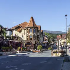 Tętniące życiem karpacz centrum z charakterystyczną architekturą, kawiarniami i górami w tle.