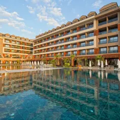 Basen i tarasy hotelu Aletris Deluxe Hotel & Spa. Woda w basenie odbija nowoczesną architekturę hotelu.