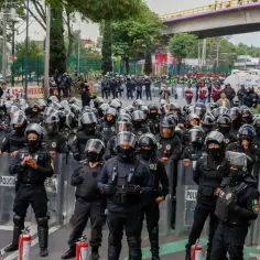 Tłum policjantów w pełnym rynsztunku, z tarczami, gotowy do akcji podczas zamieszek w Meksyku.