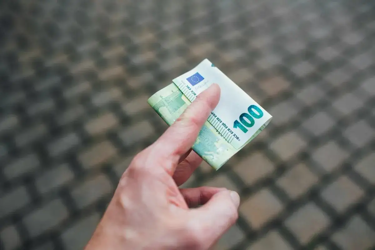 Dłoń trzyma banknot 100 euro, waluta w Grecji.