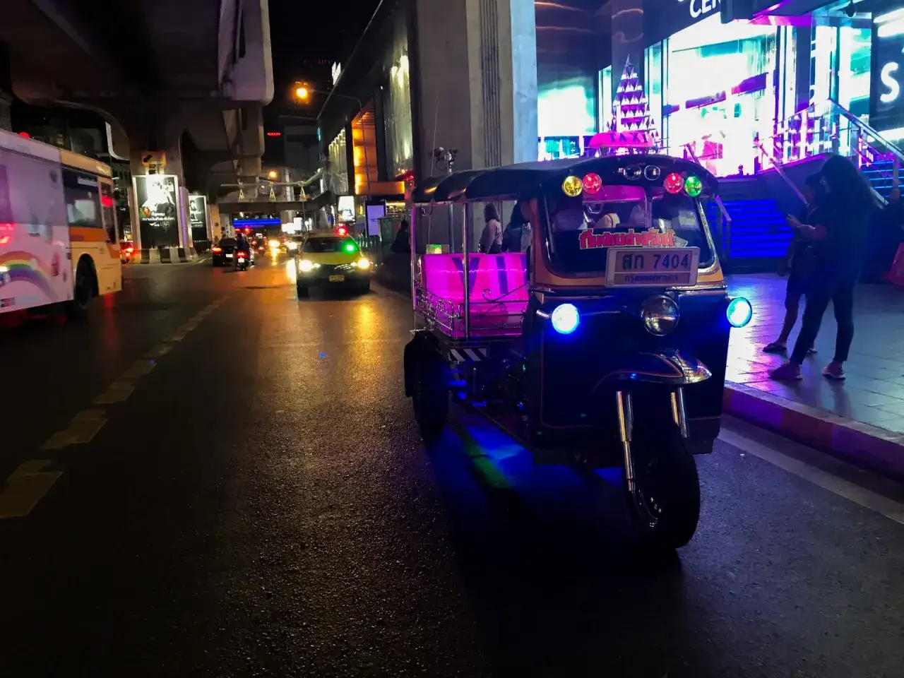 Nocne Bangkok: tuk-tuk z neonowym oświetleniem i taksówka. Czy Tajlandia jest bezpieczna? Tak, podróżowanie nocą jest bezpieczne.