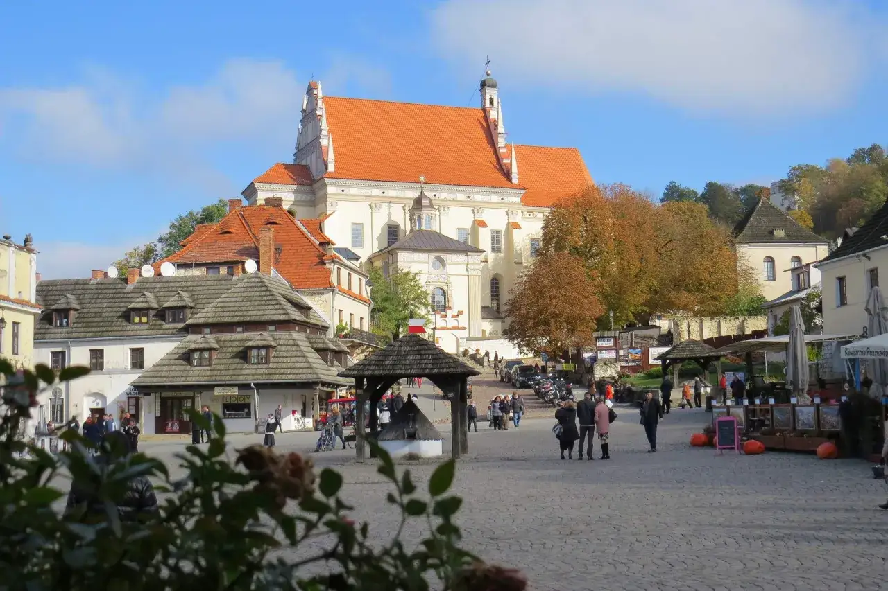 Rynek w Kazimierzu Dolnym, jedno z ciekawe miejsca 150 km od Warszawy. Piękna architektura, jesienne drzewa i ludzie spacerujący po bruku.