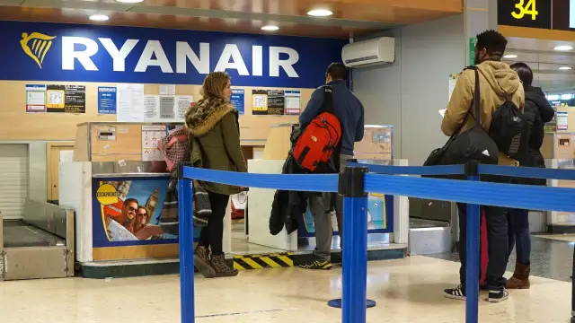 Klienci stoją w kolejce do odprawy Ryanair. Zastanawiasz się, ile kosztuje odprawa na lotnisku?