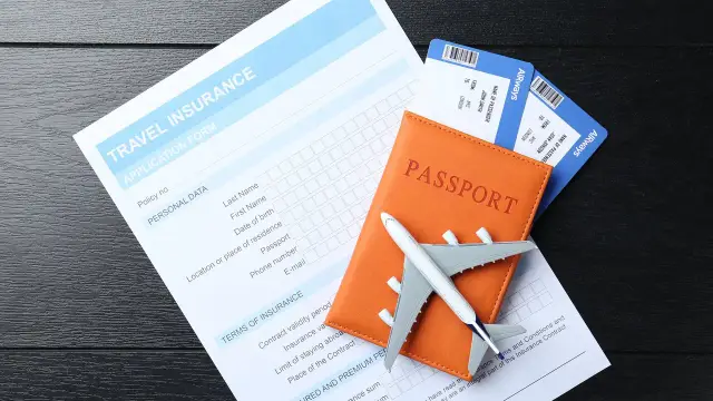 Planujesz podróż? Na zdjęciu paszport, bilety lotnicze i formularz ubezpieczenia podróżnego. Czy do Irlandii potrzebny jest paszport? Tak, jest niezbędny!